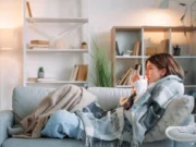 6 gestes pour vous protéger contre les virus de l’hiver femme allongée sur son canapé, sous une couverture