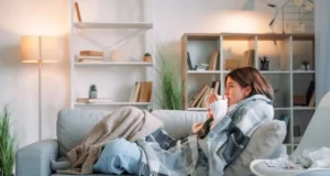 6 gestes pour vous protéger contre les virus de l’hiver femme allongée sur son canapé, sous une couverture