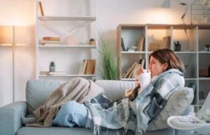 6 gestes pour vous protéger contre les virus de l’hiver femme allongée sur son canapé, sous une couverture